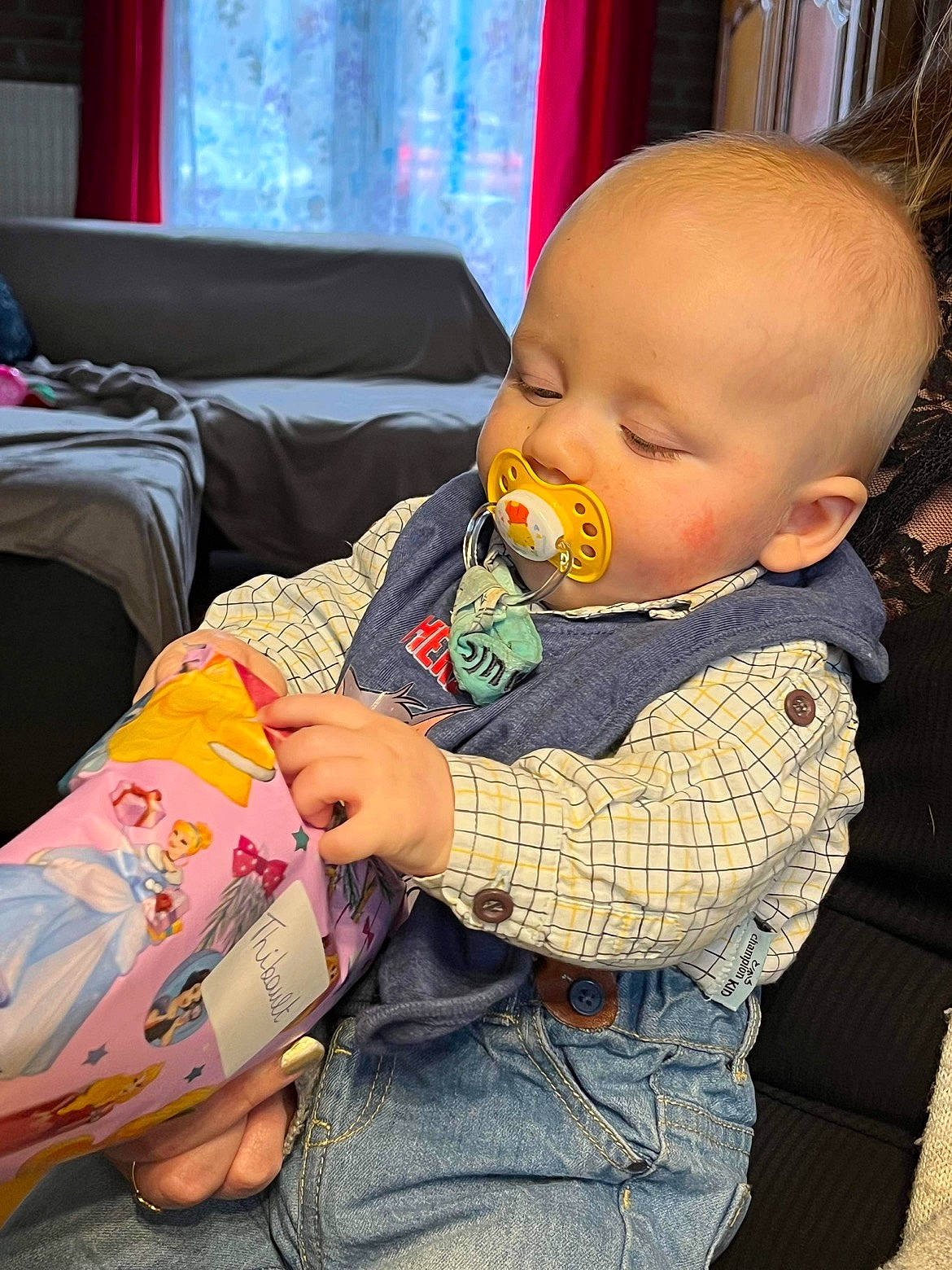 Thibault participe au concours pour gagner de l'argent avec cette photo : baby, baby_products, baby_toddler_clothing, cheek, child, comfort, curtain, flooring, human_body, lap, linens, pattern, person, play, room, sitting, skin, sleeve, textile, toddler