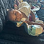 Sevyn is registered to the contest to win money with this photo: baby, infant, blanket, quilt, lying_down, face, smile, curious, indoors, soft_texture, cozy, child, person, cute, head, skin, clothing, comfort, resting, young