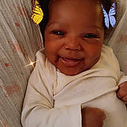 Sevyn is registered to the contest to win money with this photo: baby, smiling, infant, onesie, butterflies, digital_effects, dimples, lying_down, blanket, cute, happy, child, portrait, closeup, indoors, cozy, young_child, face, skin, hands