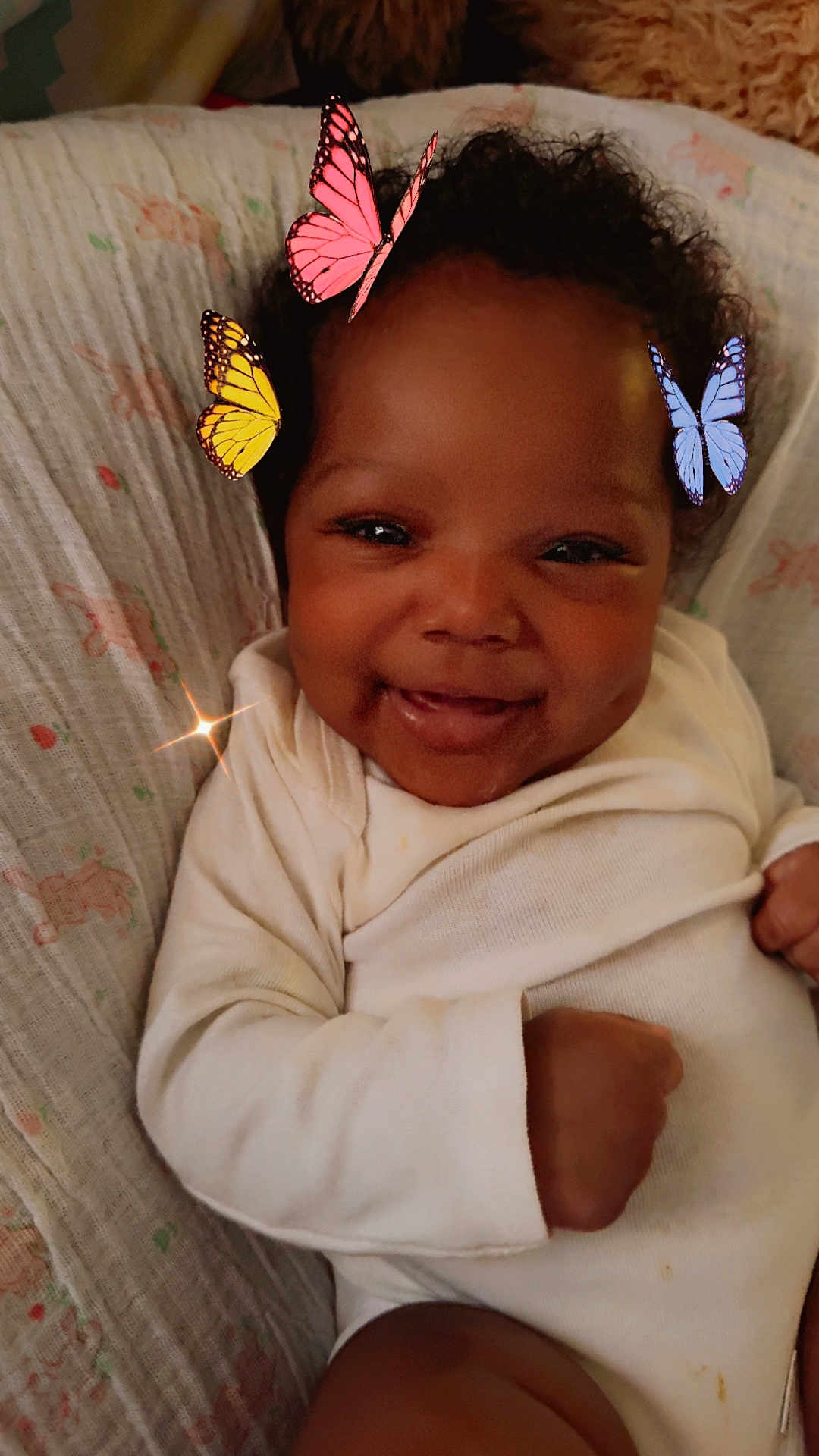 Sevyn is registered to the contest to win money with this photo: baby, smiling, infant, onesie, butterflies, digital_effects, dimples, lying_down, blanket, cute, happy, child, portrait, closeup, indoors, cozy, young_child, face, skin, hands