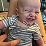 baby, infant, striped_clothing, onesie, smile, funny_face, hand, tickle, person, indoor, legs, skin, expression, cute, child, happy, human, closeup, sitting, tattoo