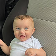 Micah joined the competition — help win amazing prizes! baby, child, car_seat, white_clothing, smiling, blue_eyes, happy, infant, cute, sitting, portrait, one_person, indoors, casual, human, young_child, cute_baby, car_interior, seat, clothing