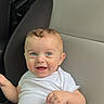 baby, child, car_seat, white_clothing, smiling, blue_eyes, happy, infant, cute, sitting, portrait, one_person, indoors, casual, human, young_child, cute_baby, car_interior, seat, clothing