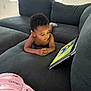 Aspen is registered to the contest to win money with this photo: toddler, child, couch, laptop, screen, indoor, curly_hair, blanket, window, light, watching, technology, furniture, relaxing, home, cozy, device, casual, young_child, concentration