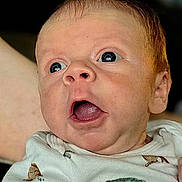 Jalen is registered to the contest to win money with this photo: baby, infant, face, expression, surprised, clothing, onesie, animal_print, skin, head, eyes, mouth, portrait, indoor, person, newborn, cute, child, screenshot, smartphone