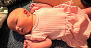 Evelyn is registered to the contest to win money with this photo: baby, infant, pink_clothing, lying_down, blanket, newborn, soft_texture, peaceful, indoors, child, small_hands, cute, sleepy, person, portrait, resting, closeup, skin, head, cozy