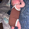 Evelyn joined the competition — help win amazing prizes! baby, infant, child, portrait, lying_down, blanket, bed, onesie, brown_clothing, blue_blanket, sleeping_area, baby_hand, baby_feet, adult_hand, indoor, home, cozy, candid, flash_photography, family