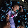 Ayla is registered to the contest to win money with this photo: baby, blanket, child, clothing, comfort, cozy, cute, face, hand, indoors, infant, legs, pacifier, relaxation, resting, skull_pattern, sleeping, soft_light, toddler, wearing_bib