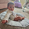 baby, child, infant, cushion, polka_dot, indoor, carpet, plush_chair, plant, window, furniture, reaching, curious, white_clothing, bib, foot, hand, face, living_room, home