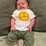 Liam joined the competition — help win amazing prizes! baby, child, smile, tshirt, lion_graphic, green_pants, cushions, indoor, portrait, happy, infant, cute, sitting, comfortable, cozy, skin, face, person, clothing, apparel