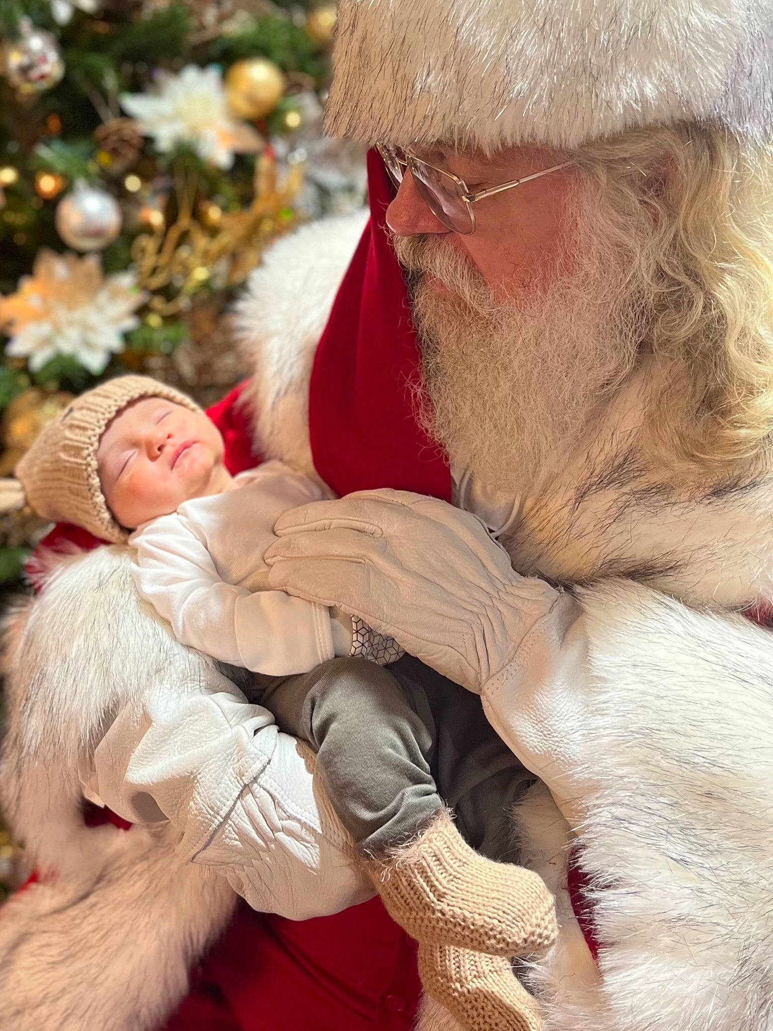 Noel joined the competition — help win amazing prizes! baby, beard, cap, comfort, event, face, facial_hair, fur, grass, happy, hat, headwear, lap, people_in_nature, person, santa_claus, sitting, skin, sunglasses, toddler