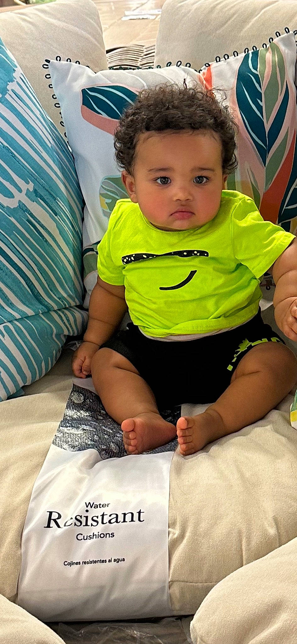 Noel is registered to the contest to win money with this photo: baby, baby_toddler_clothing, chair, child, comfort, event, eye, facial_expression, fun, hairstyle, happy, leisure, linens, person, room, sitting, skin, sleeve, t_shirt, thigh