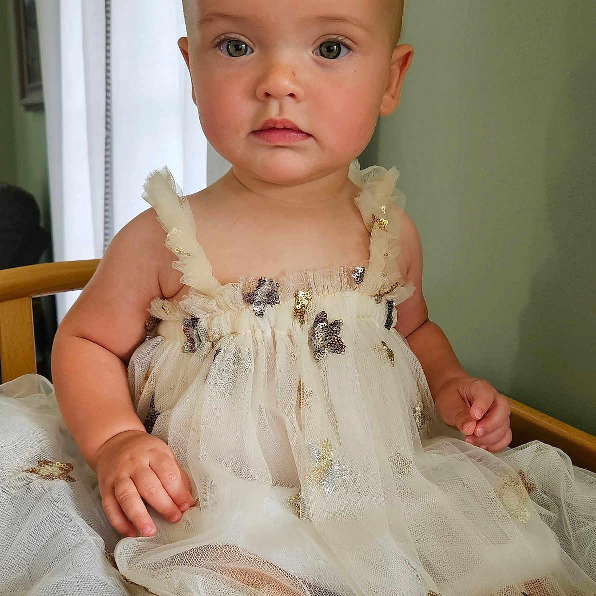 Baylin joined the competition — help win amazing prizes! child, toddler, dress, sparkles, headband, sitting, chair, indoors, portrait, baby, face, calm, cute, furniture, wall, natural_light, young_child, person, fashion, soft_colors