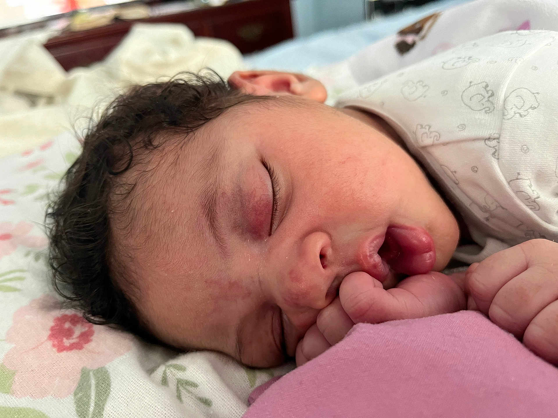 Eliana Izia joined the competition — help win amazing prizes! baby, sleeping, close_up, face, hand, curly_hair, blanket, pattern, floral, infant, peaceful, resting, cute, newborn, pink, skin, mouth, finger, soft_lighting, indoors