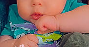 Zara joined the competition — help win amazing prizes! baby, infant, child, face, eyes, wide_eyed, indoor, portrait, close_up, sitting, turquoise_shirt, clothing, hands, fist, adult_arm, heart_sticker, date_text, text_overlay, home, photograph
