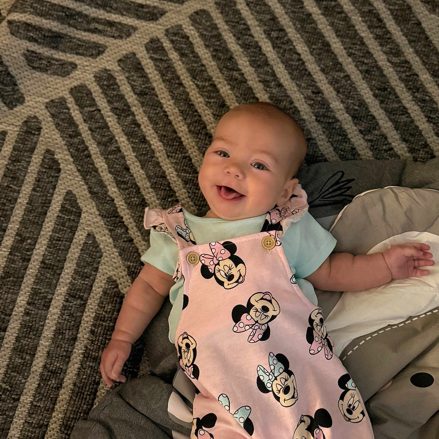 Saylor joined the competition — help win amazing prizes! baby, babylaughing, blanket, clothing, couch, cushion, dress, face, furniture, happy, head, homedecor, laughing, pants, person, photography, portrait, quilt, sitting, smile