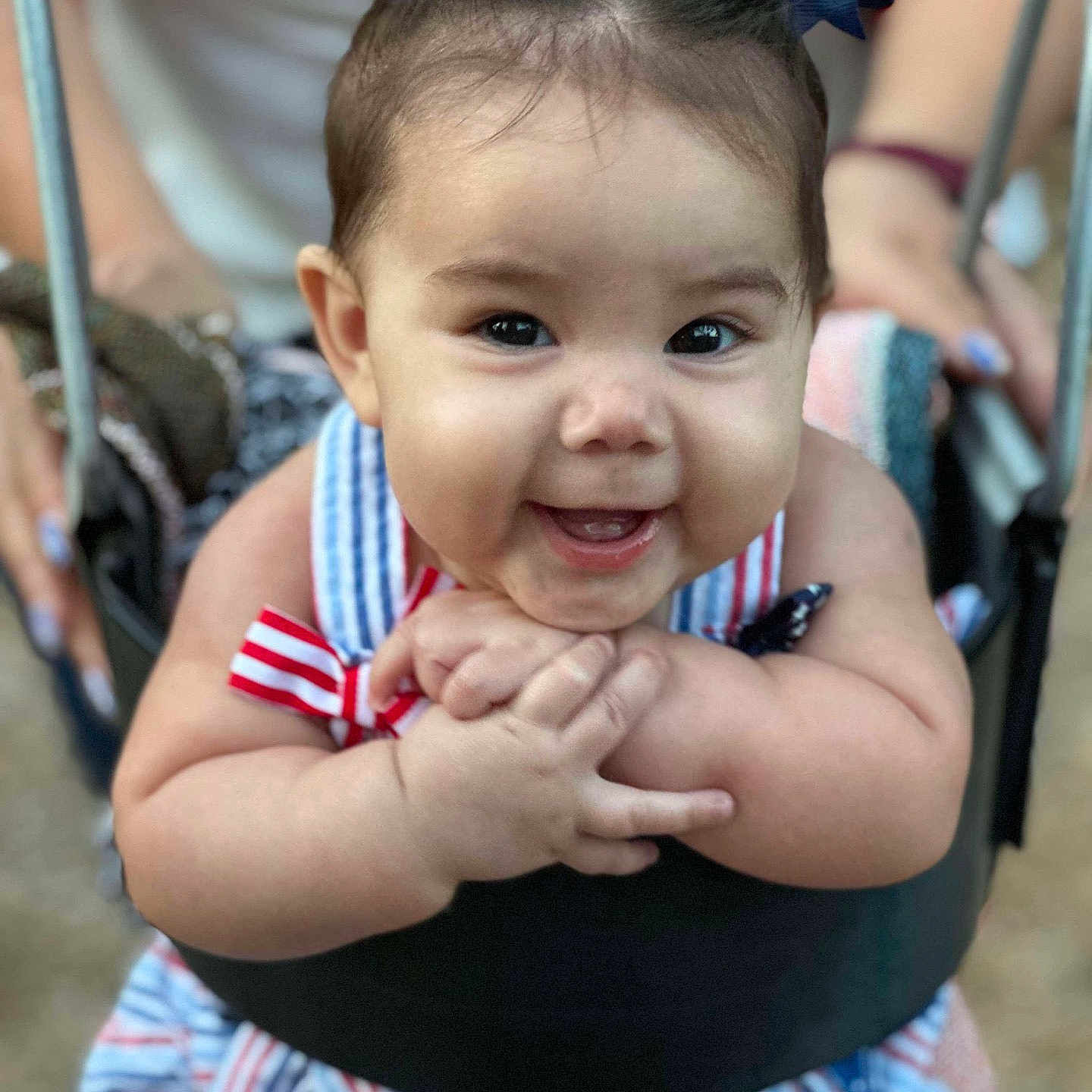 Isabella is registered to the contest to win money with this photo: baby, bows, child, closeup, cute, dress, fun, hair, hands, happy, infant, joyful, outdoor, person, playground, seat, smiling, striped, swing, young