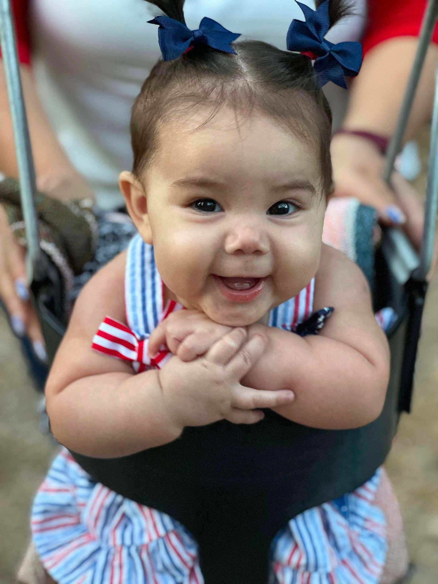Isabella is registered to the contest to win money with this photo: baby, child, smiling, swing, bows, hair, hands, dress, striped, happy, outdoor, person, cute, infant, closeup, playground, joyful, young, seat, fun