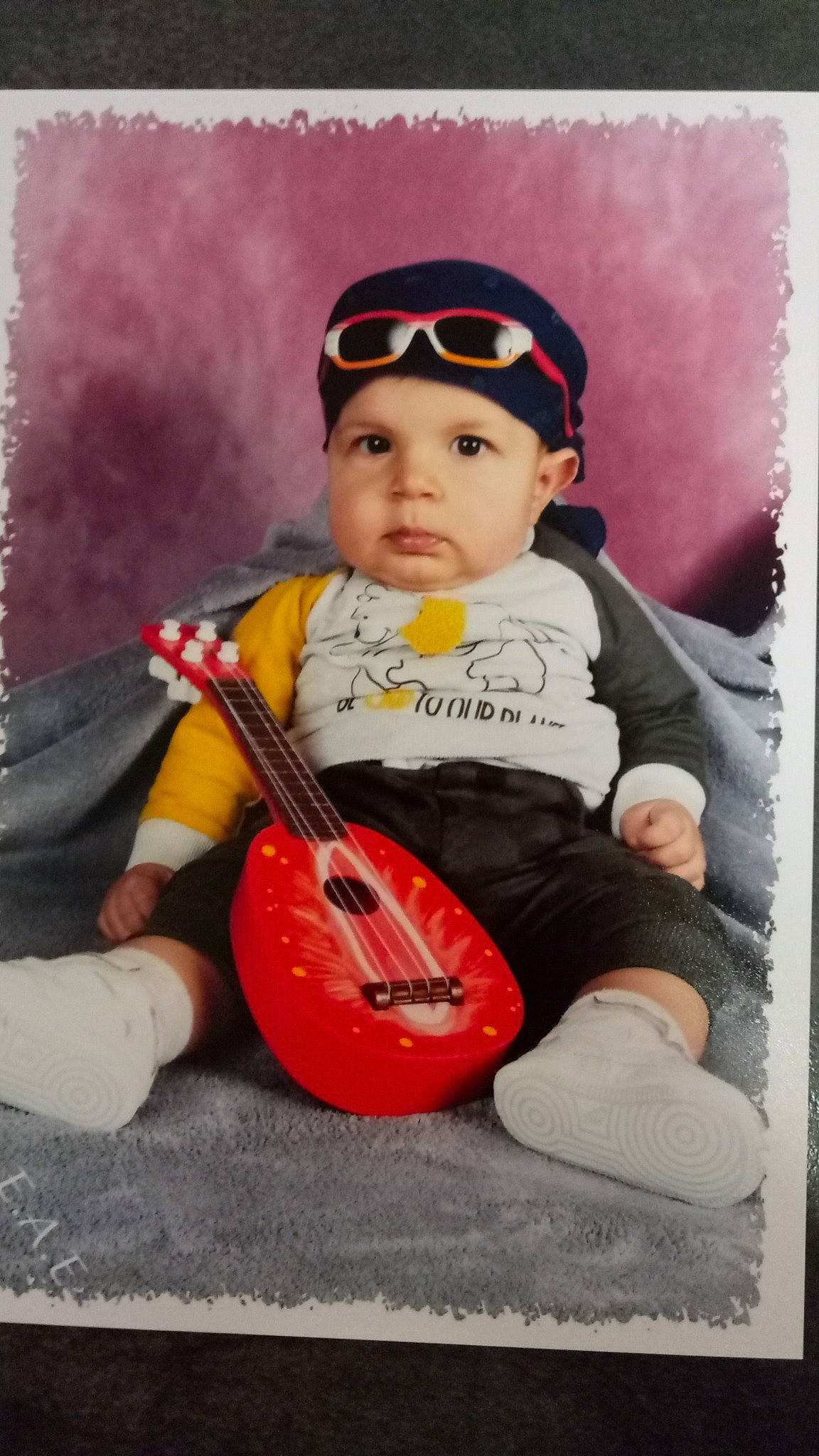 Kassim a rejoint le concours — aidez-le/la à gagner de superbes lots ! art, baby, baby_carriage, baby_products, baby_toddler_clothing, cap, child, clothing, eyewear, goggles, happy, hat, headwear, musical_instrument, person, personal_protective_equipment, plucked_string_instruments, sitting, stock_photography, string_instrument