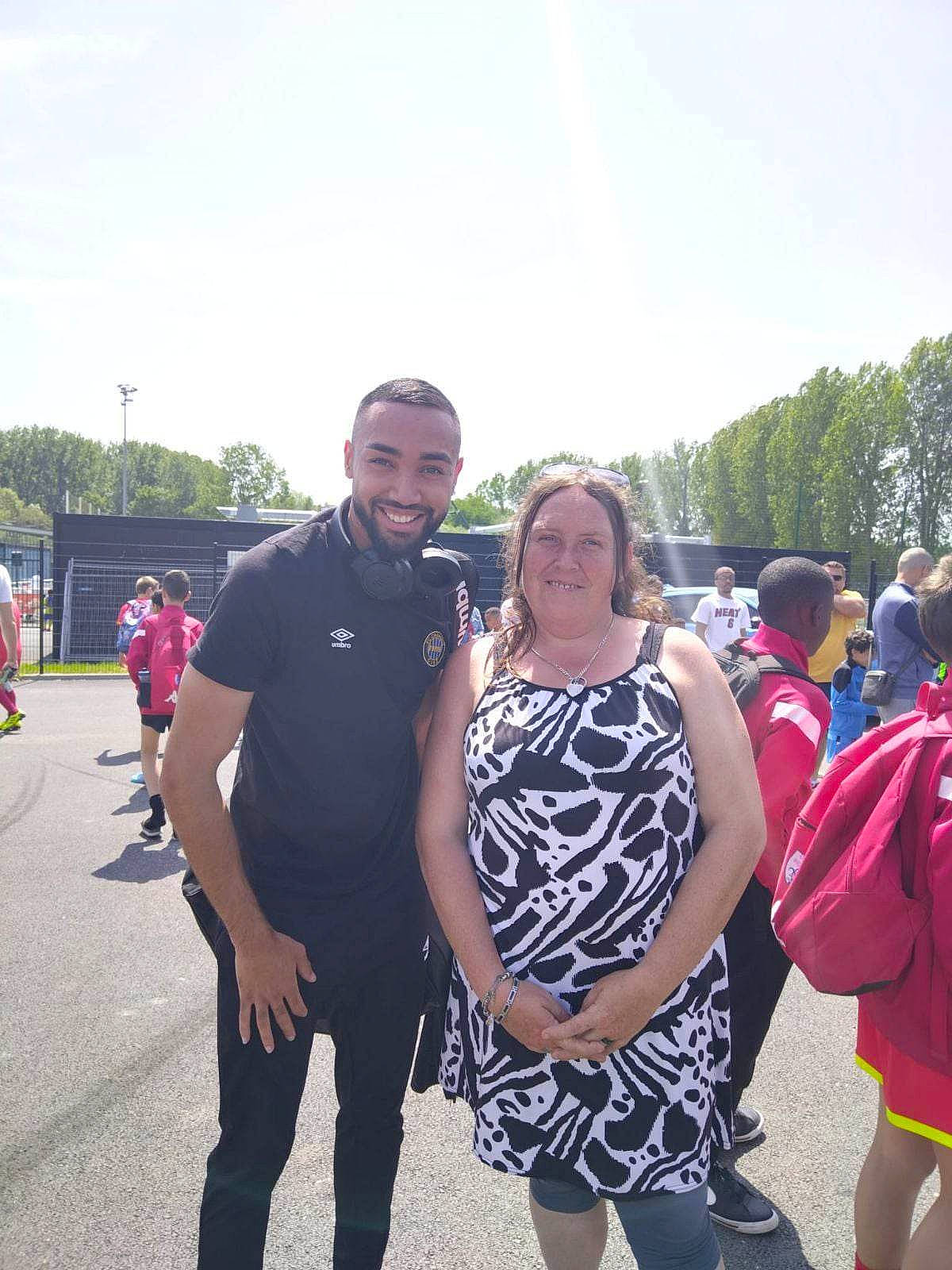 Shirley a rejoint le concours — aidez-le/la à gagner de superbes lots ! backpack, bag, boot, crowd, event, eyewear, footwear, fun, handbag, joy, leisure, luggage_and_bags, luxury_vehicle, person, public_event, recreation, sky, smile, t_shirt, team