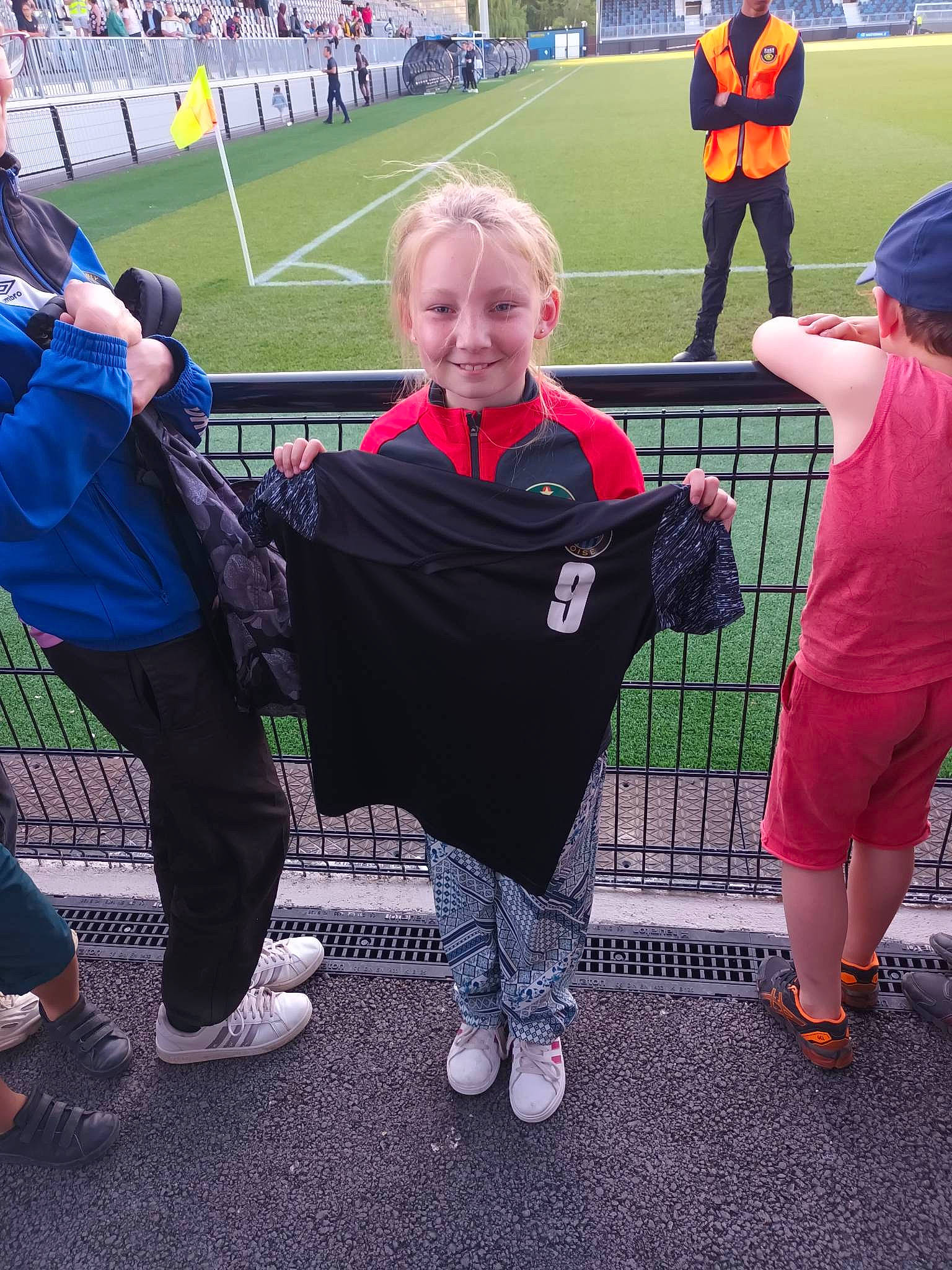 Shirley participe au concours pour gagner de l'argent avec cette photo : crowd, event, fan, fun, gesture, grass, jersey, joy, leisure, person, player, product, shoe, shorts, smile, sneakers, sportswear, t_shirt, team, tournament