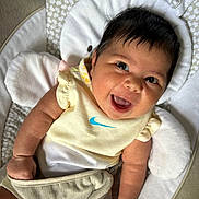 Mia joined the competition — help win amazing prizes! baby, smile, infant, cute, happy, child, clothing, yellow, soft_toy, cushion, bunny, pattern, face, person, portrait, indoors, skin, hand, head, sitting