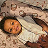 Taliyah is registered to the contest to win money with this photo: baby, smiling, infant, blanket, owl_pattern, hand_holding, cute, lying_down, soft_toy, cozy, child, person, indoors, toddler, clothing, happy, face, portrait, bed, parent