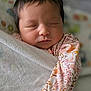newborn, baby, sleeping, blanket, floral_clothing, infant, closeup, face, peaceful, soft_lighting, indoors, portrait, cute, young_child, wrapped, resting, skin, head, hair, child