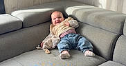 Rose a rejoint le concours — aidez-le/la à gagner de superbes lots ! baby, child, couch, sofa, plush_toy, jeans, socks, sweater, smiling, indoor, living_room, wood_paneling, sunlight, relaxing, furniture, comfort, happy, person, casual_clothing, cozy