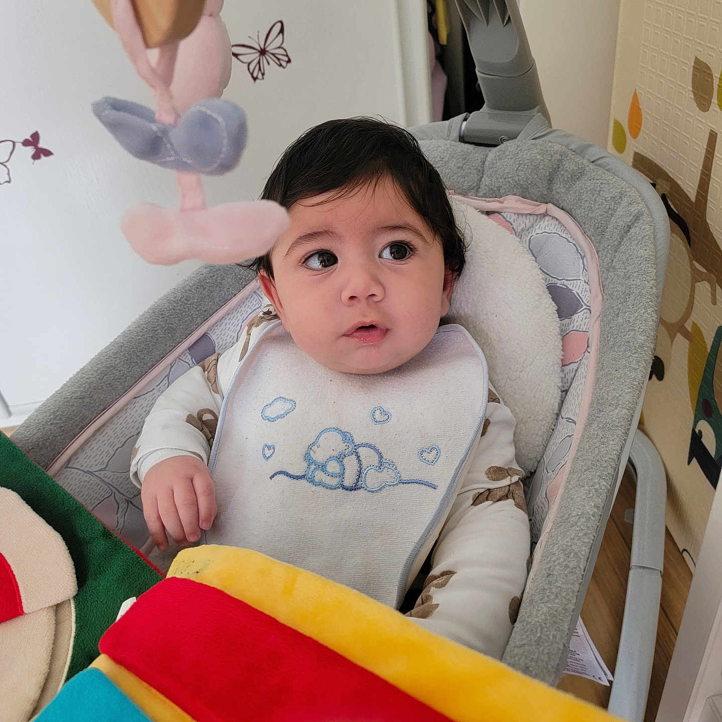 Eylen a rejoint le concours — aidez-le/la à gagner de superbes lots ! baby, bib, blanket, butterfly, child, clothing, colorful, curious, cushion, face, home, indoor, infant, person, rocker, seated, soft_toy, toy, wall_decor, young