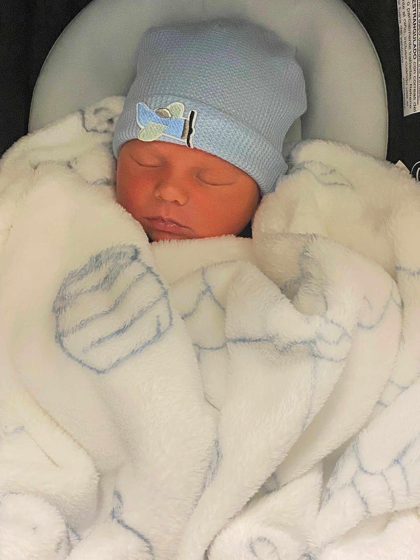 Adam is registered to the contest to win money with this photo: newborn, baby, sleeping, blanket, blue_hat, infant, cozy, soft_texture, face, closed_eyes, cushion, car_seat, cute, peaceful, indoor, child, portrait, warm, resting, baby_clothing