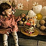 toddler, child, birthday_cake, balloons, flower_decor, pink_dress, celebration, indoor, happy, smiling, candle, cake, table, wooden_surface, flowers, decorations, party, first_birthday, person, festive