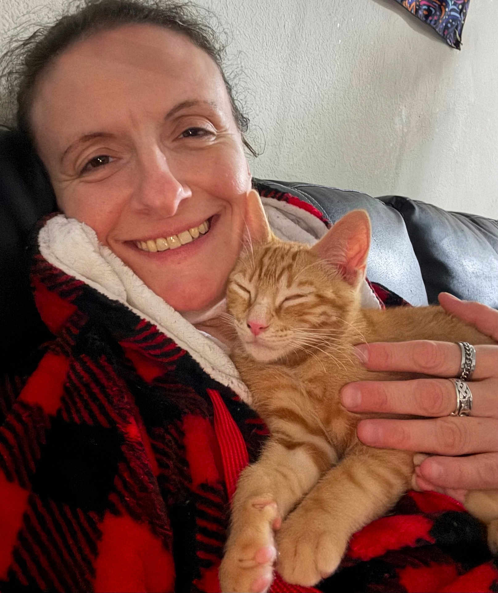 Cheeto joined the competition — help win amazing prizes! person, smiling_person, cat, ginger_cat, tabby, kitten, sleeping_cat, pet, cuddle, cuddling, hand, rings, jewelry, blanket, plaid_blanket, sofa, indoor, portrait, happy, cozy
