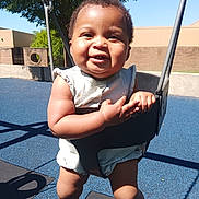 Reina joined the competition — help win amazing prizes! baby, child, swing, playground, smile, sunlight, outdoor, happy, infant, blue_floor, tree, clothing, arms, legs, shadow, metal_chain, park, daylight, person, cute