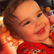 Maliyah joined the competition — help win amazing prizes! toddler, child, smile, curly_hair, red_shirt, cars_theme, toy, indoor, sunlight, happy, face, freckles, playful, colorful, closeup, portrait, candid, cute, warm_light, expression