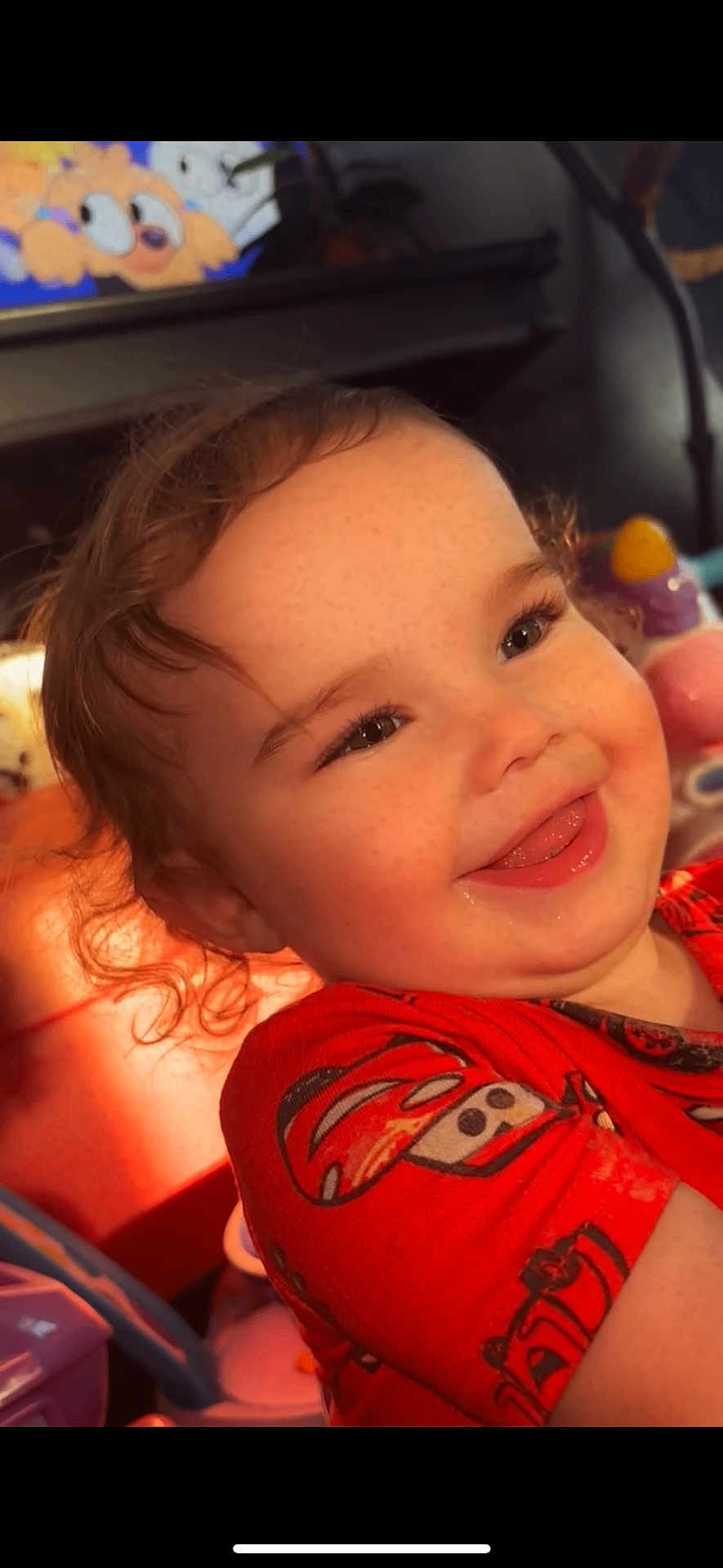 Maliyah joined the competition — help win amazing prizes! toddler, child, smile, curly_hair, red_shirt, cars_theme, toy, indoor, sunlight, happy, face, freckles, playful, colorful, closeup, portrait, candid, cute, warm_light, expression