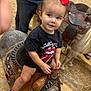 Maliyah joined the competition — help win amazing prizes! toddler, child, pony, saddle, red_bow, black_tshirt, jeans, wood_shavings, fence, footwear, converse_shoes, animal_ride, indoor, person, curly_hair, cute, holding_reins, smiling, small_horse, casual_clothing