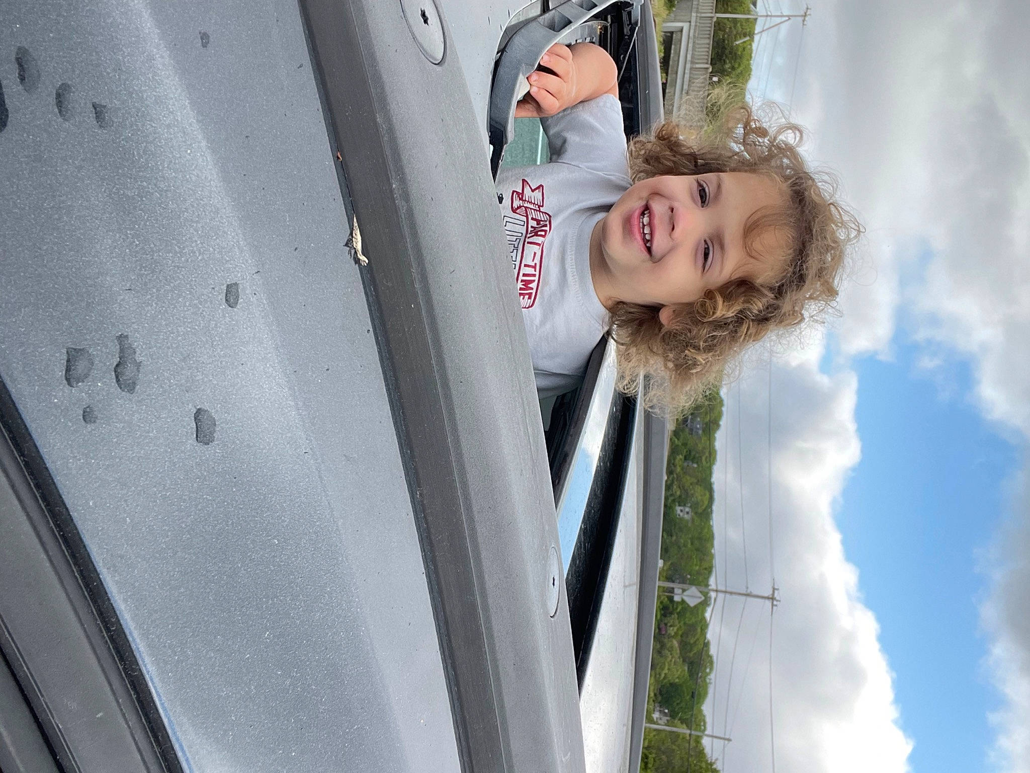 Jayce is registered to the contest to win money with this photo: child, cloud, daytime, design, facade, fun, glass, happy, joy, leisure, person, plant, reflection, sky, smile, toddler, tree, vehicle_door, window, wood