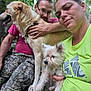 Shivers is registered to the contest to win money with this photo: outdoor, people, man, woman, dog, large_dog, small_dog, pet, forest, greenery, camouflage_pants, casual_clothing, nature, leash, portrait, selfie, animal, holding, relaxed, companionship