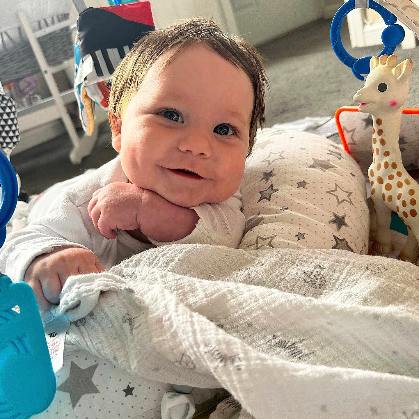 Tayler joined the competition — help win amazing prizes! baby, baby_gym, blanket, carpet, child, closeup, colorful, cushion, face, floor, giraffe, hand, happy, head, indoor, infant, playing, smiling, toy, white_clothing