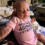 Emma Wyatt is registered to the contest to win money with this photo: accessories, baby, bed, bedroom, bodypart, clothing, couch, face, finger, furniture, hand, head, indoors, newborn, person, photography, portrait, room, sitting, t_shirt