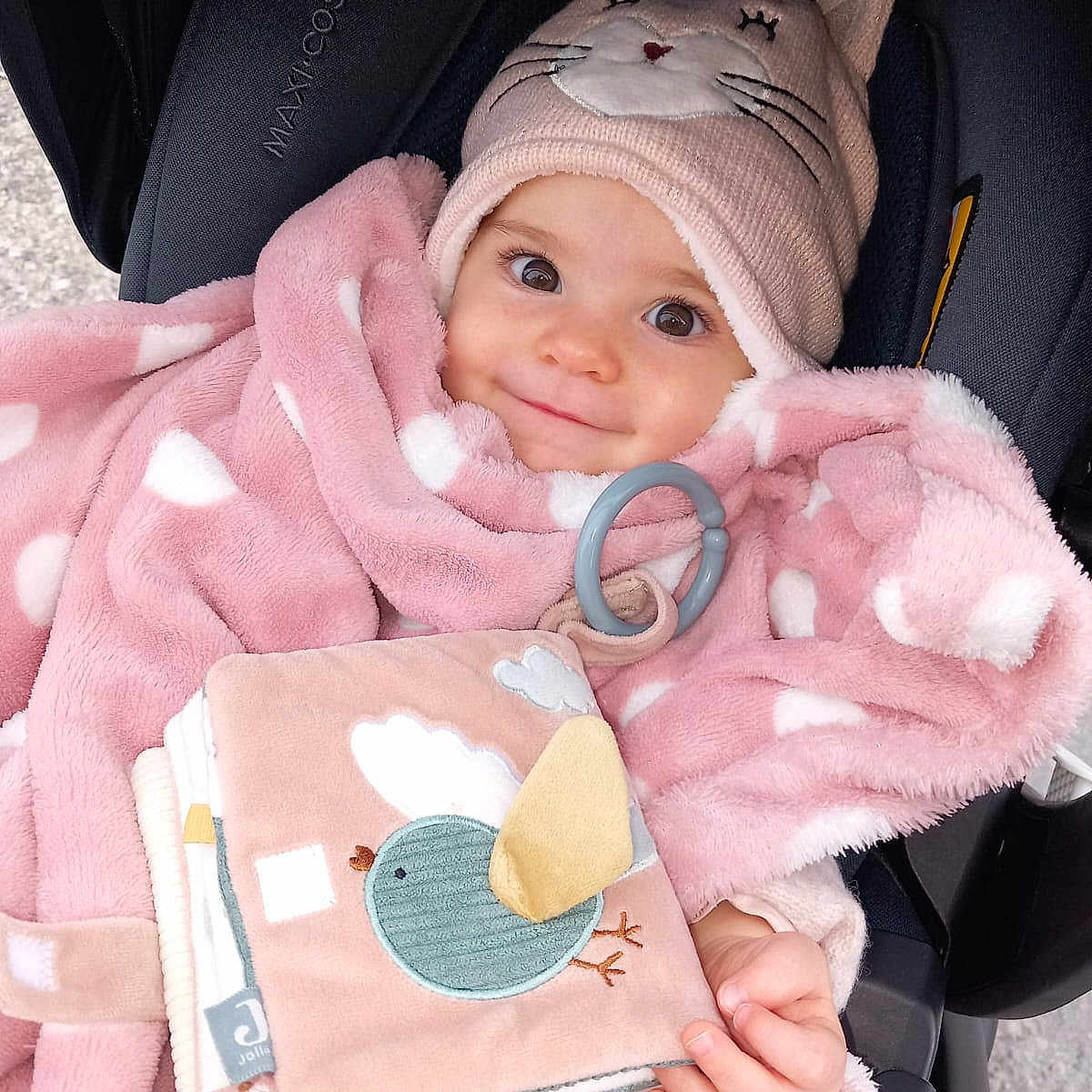 Ophélia a rejoint le concours — aidez-le/la à gagner de superbes lots ! baby, blanket, car_seat, child, clothing, cute, fabric_book, face, hand, hat, indoors, infant, person, pink, polka_dot, portrait, smile, soft_toy, toy, warm
