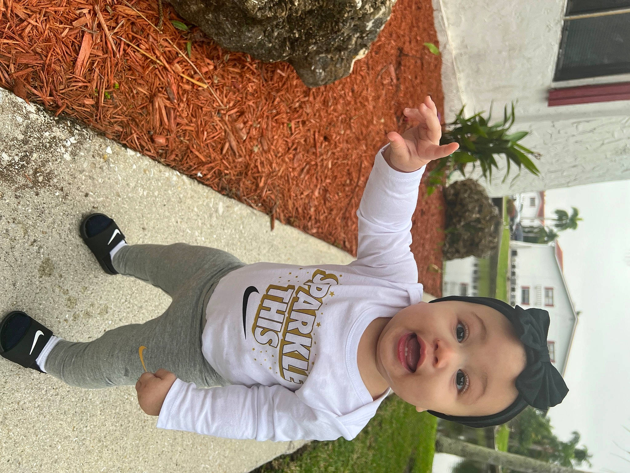 Ariella is registered to the contest to win money with this photo: baby_toddler_clothing, child, flowerpot, fun, grass, happy, houseplant, leaf, leisure, people_in_nature, person, photograph, plant, smile, snapshot, soil, surprise, t_shirt, toddler, tree