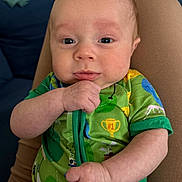 Rowan joined the competition — help win amazing prizes! baby, infant, child, green_onesie, hand, face, person, sitting, lap, curious, indoor, closeup, cute, young, skin, eyes, expression, comfortable, colorful_clothing, resting