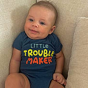 Waylon is registered to the contest to win money with this photo: baby, beige, child, comfortable, couch, cute, face, furniture, happy, head, indoors, infant, onesie, person, portrait, sitting, skin, smiling, text_clothing, young