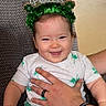 Alice is registered to the contest to win money with this photo: baby, child, smiling, irish_princess, headband, shamrock, green, pajamas, hand, adult, chair, indoor, happy, cute, portrait, person, sitting, clothing, celebration, holiday