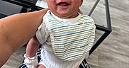 Kross is registered to the contest to win money with this photo: adult, baby, bib, casual, clothing, floor, foot, furniture, glass, hair, hand, happy, holding, indoor, infant, legs, person, skin, smiling, table