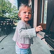 Elise a rejoint le concours — aidez-le/la à gagner de superbes lots ! toddler, child, outdoor, sweater, jeans, handle, door, window, tree, sky, fence, table, chair, curious, person, building, concrete, daylight, young_child, casual_clothing