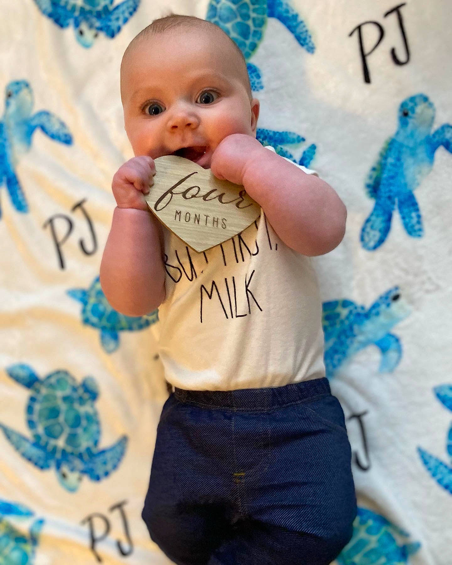Parker is registered to the contest to win money with this photo: abdomen, aqua, azure, baby, baby_toddler_clothing, blue, cheek, child, electric_blue, finger, font, gesture, happy, pattern, person, skin, sleeve, smile, t_shirt, textile