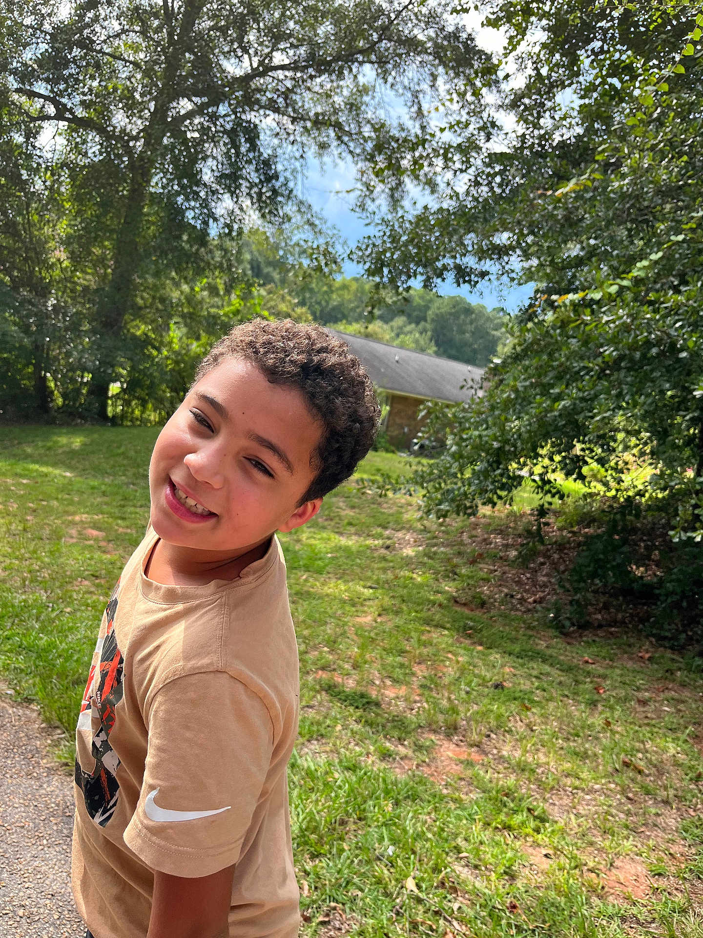 Elijah joined the competition — help win amazing prizes! child, boy, curly_hair, smile, outdoor, grass, trees, sunny, tshirt, nike, playful, nature, house, greenery, daylight, person, portrait, casual, happy, young